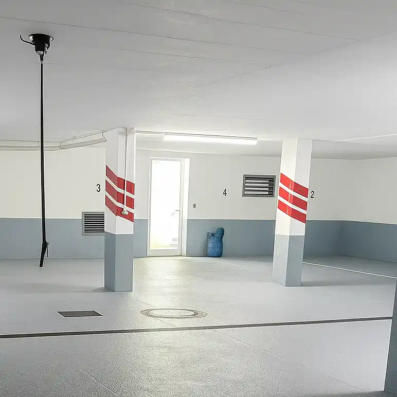 Fertig renovierte Tiefgarage in Augsburg mit sanierten Wänden und Bodenbeschichtung